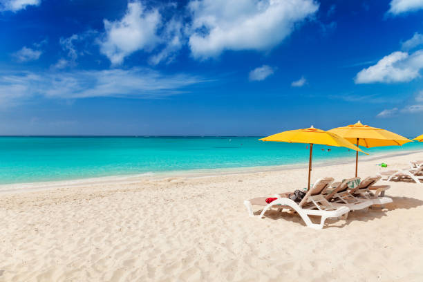 Grace Bay Beach Vivid blues and turquoise with white sands, Grace Bay Beach, Turks & Caicos. Bright yellow beach umbrellas make a great contrast color providenciales stock pictures, royalty-free photos & images