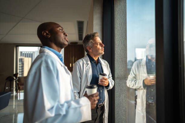 Contemplative doctors looking throught the window in the hospital