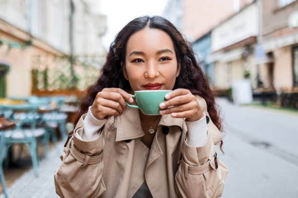 istock Smiling Chinese woman drinking coffee 1492672345
