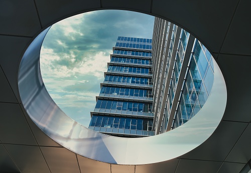 Raanana, Israel, December 17, 2022. Modern building through a hole in the ceiling, dramatic sky.