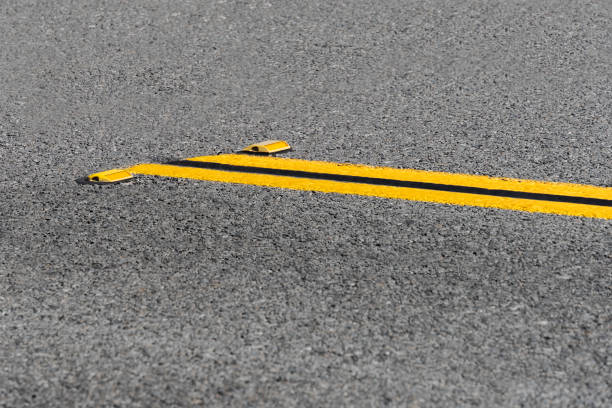 istock Double yellow lines on asphalt road with reflectors 1492674663