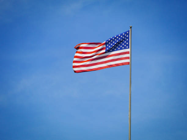 Low angle view of american flag against blue sky