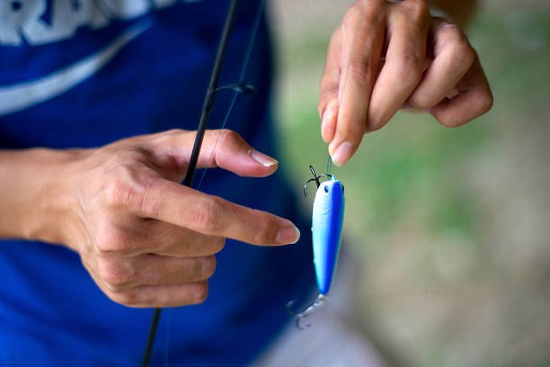 A fisherman tying a lure to his line.