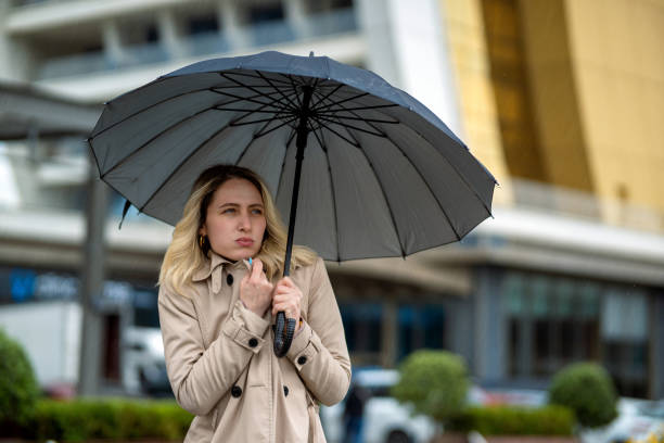 istock Woman with umbrella feeling cold on a rainy day 1492677609