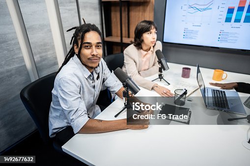 istock Portrait of young man during the recording of an online show with colleagues 1492677632