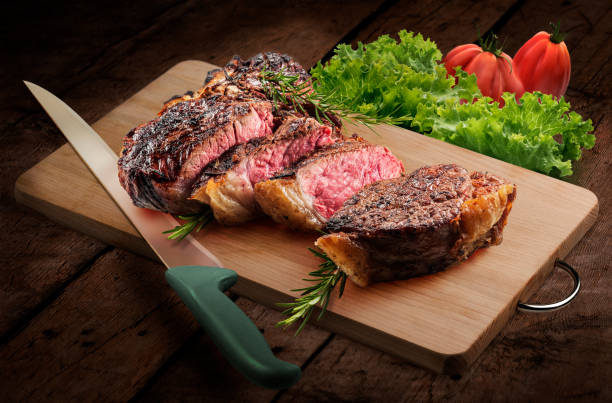istock Fiorentina T-bone steak cut on rectangular wooden chopping board with knife and vegetables 1492679285