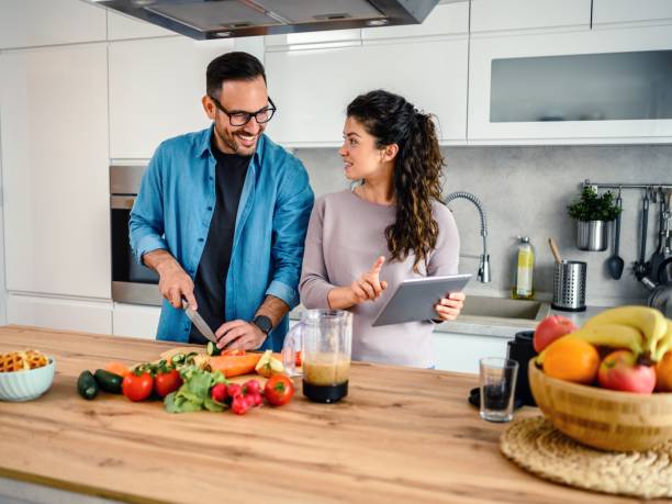 istock Loving couple having fun cooking together at home 1492679418