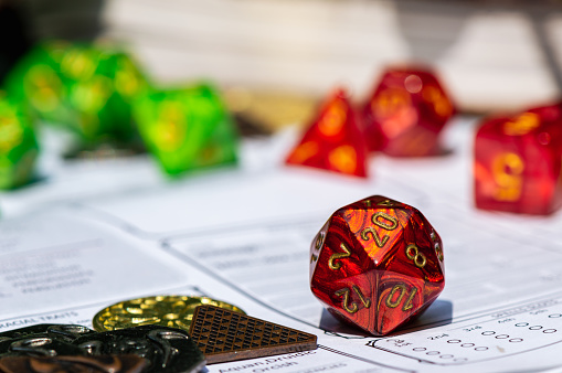 A  macro image of a red Role-playing gaming die on a character sheet