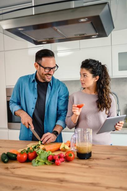 istock Loving couple having fun cooking together at home 1492680545