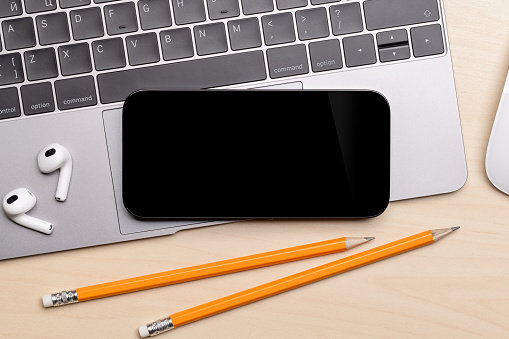 Blank black screen smartphone on a desk, perfect for your design mockup