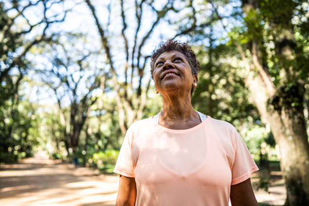 kontemplacyjna starsza kobieta patrząc w górę w parku - exercising motivation looking up african descent zdjęcia i obrazy z banku zdjęć