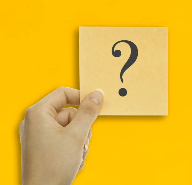 istock Women hand holding sticky note with question mark on yellow background. 1492681020