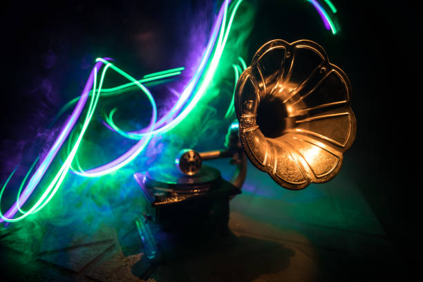 istock Music concept. Old gramophone on a dark background. Retro gramophone with disc on wooden table with toned backlight. 1492682014