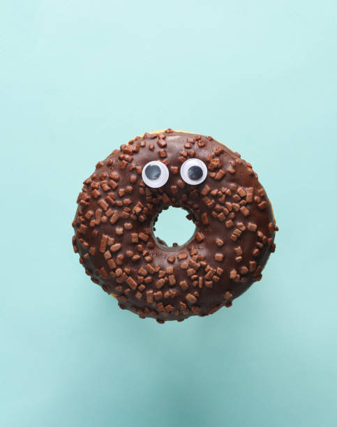 istock Chocolate donut with scared eyes on a blue background. Halloween concept 1492682365