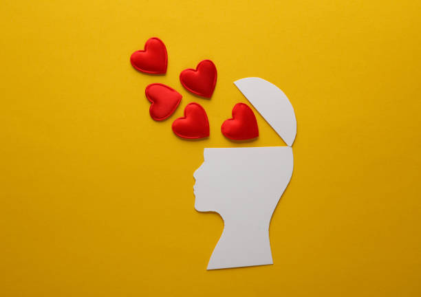 istock Paper-cut open human head with hearts on yellow background. Love concept 1492682418
