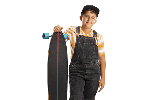 Boy posing with a longboard and smiling at camera isolated on white background