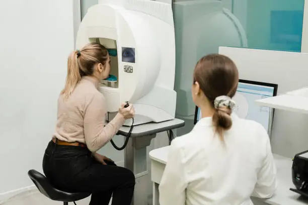 Photo of Perimetry eyes test for early sign of glaucoma of woman patient of ophthalmology clinic. Perimetry visual field test for measure all areas of eyesight, including side, or peripheral vision.