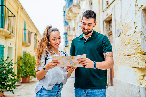 Cheerful young couple using a map in Valletta, Malta