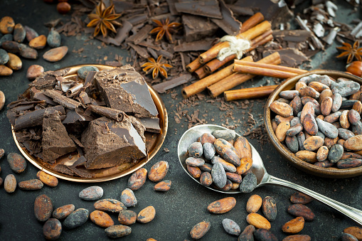 Cocoa beans in a composition with kitchen accessories.