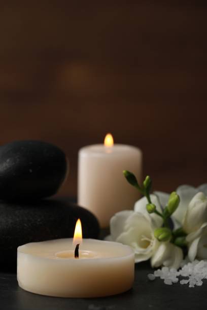 istock Beautiful composition with spa stones, burning candles and flowers on black table 1492704229