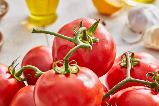 Beautiful ripe fresh organic tomato on the kitchen table, home or restaurant, representing a health lifestyle, wellbeing and body care.