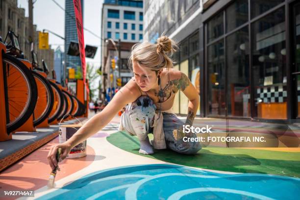 Young Caucasian Woman Artist Painting Sidewalk Mural Stock Photo - Download Image Now