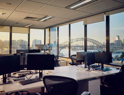 Australian office with view of Sydney harbour, empty in the early morning light.