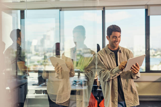 istock Smiling Man in a Shirt Using a Digital Tablet in the Office 1492719670
