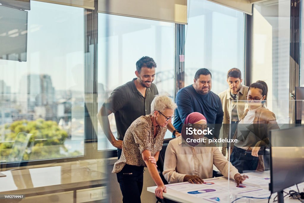 A multicultural team of professionals fostering collaboration and innovation in Sydney. Teamwork and collaboration in a tech-driven Australian office with stunning Sydney views. Multiracial Group Stock Photo