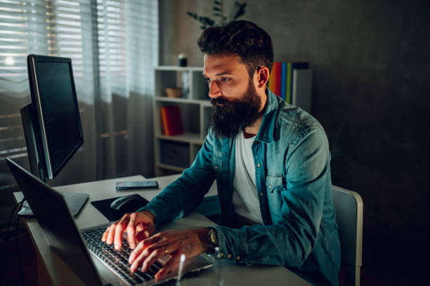istock An intelligent data and computer scientist is typing on a laptop and working remotely from his darkened home office. 1492720358
