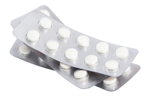 Stack of blister packs with round pills on a white isolated background