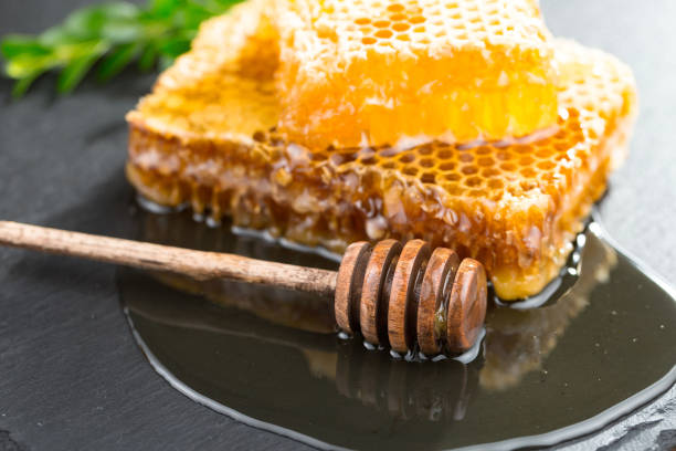 istock Honey in bee wax combs, on a wooden background. 1492721684
