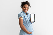 Pregnant black lady showing plaster on arm and blank screen