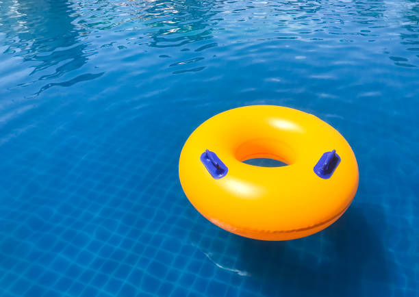 istock Yellow Ring floating in a refreshing blue swimming pool with wave reflecting in the summer time. 1492723360