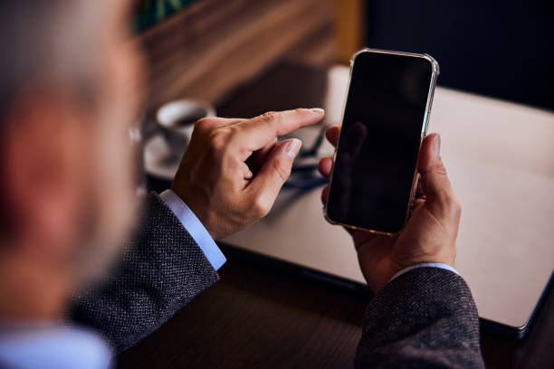 istock A close-up of a businessman using a mobile phone with a blank black screen. 1492726864
