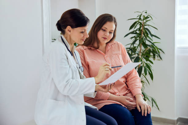 A pretty overweight on a nutritionist consultation, talking about a diet plan. A smiling female nutritionist explaining a diet plan, a balanced and healthy menu for a pretty overweight woman. pudgy woman pictures stock pictures, royalty-free photos & images