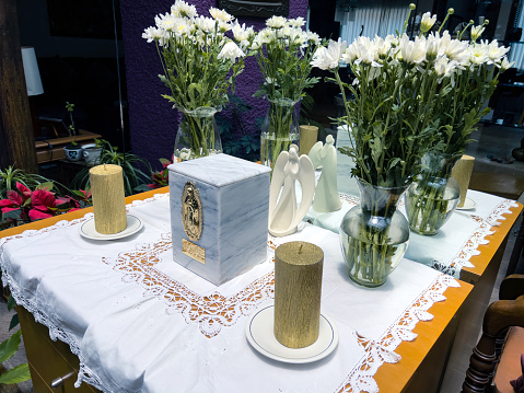 Temporary memorial for deceased relative, urn with ashes at home