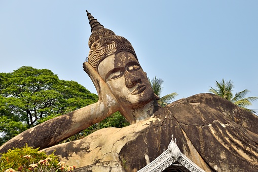 Vientiane, Laos.\nXieng Khuan Buddha Park, is located on the Mekong River about 25 kilometers southeast of Vientiane. Xieng Khuan means city of spirits. It is a sculpture park with more than 200 Buddha statues in a variety of shapes, blending Buddhist and Hindu styles.\nIt was built in 1958, it is now one of Vientiane's most famous tourist attractions.\nThis reclining Buddha is huge, 45 meters long.