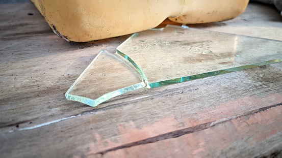 clear glass over cracked and broken surface of brown wooden planks