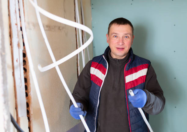 istock Electrician with cable duct in hands looking at camera 1492734535