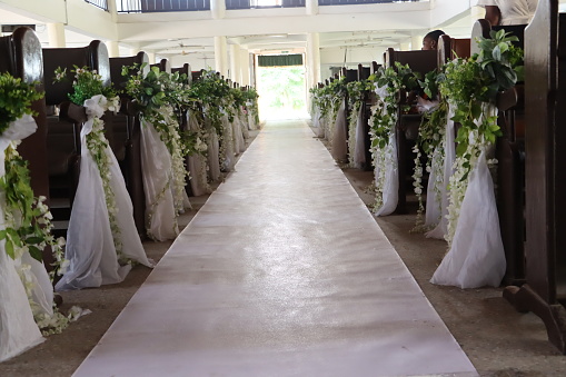 A decoration for a church wedding in royal colour with pew and beautiful flowers