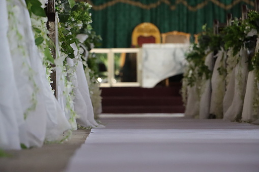 A decoration for a church wedding in royal colour with pew and beautiful flowers