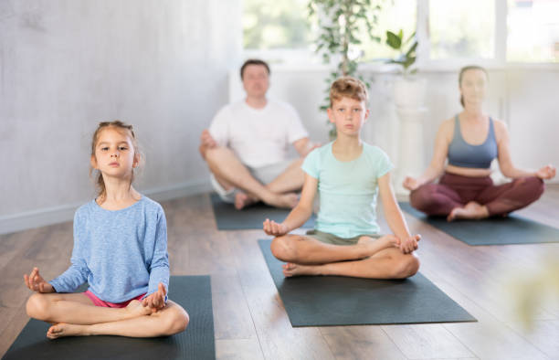 istock Child with family performs lotus pose, folding fingers in mudra of knowledge 1492736473