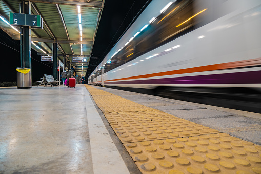 View of tracks and trains at the train station in Ronda at night.