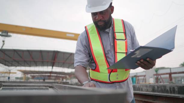istock African American engineer or contractor or foreman have expertise wearing safety uniform, inspect blocks for making precast concrete in construction site of buildings or housing projects. Worker is working in real estate construction industry. 1492764684