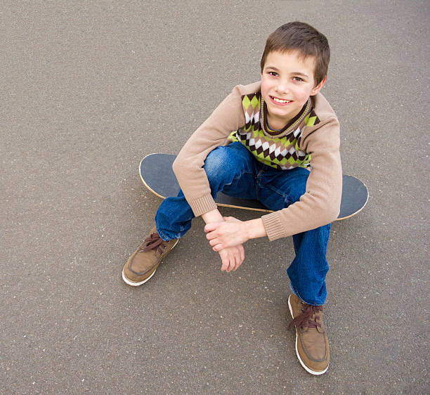 istock Cute smiling boy sitting on the skateboard 149277174