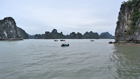 Ha Long Bay is located in Ha Long City, Quang Ning Province, Vietnam. It is a typical limestone karst landform bay. The whole bay has about 120 kilometers of coastline, a total area of about 1553 square kilometers, and about 2000 islets.\nAbout 434 square kilometers of the central area (containing 775 islets) is a World Natural Heritage Site. The scenery is beautiful and charming.\nIt is a national scenic spot in Vietnam. Countless foreign tourists come here for sightseeing.\nThere are many small fishing boats on the sea.