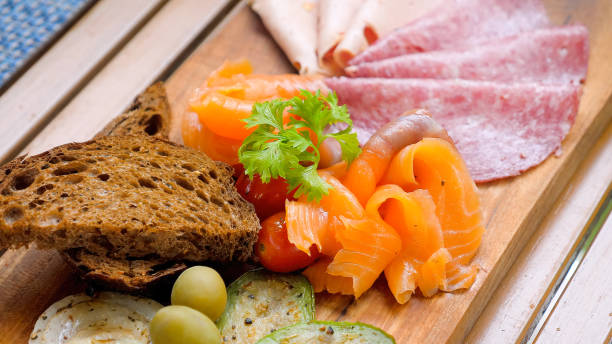 istock Close up of rustic wooden cutting board at a restaurant with cold cuts 1492774626