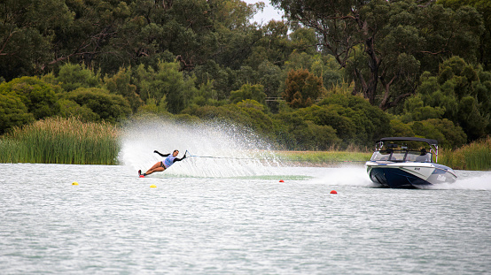 Mulwala, New South Wales Australia - 3 April 2022: Woman skier rounding a buoy at Max KIrwan Ski Park during Australian Championships