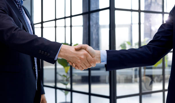 istock Two diverse professional business men executive leaders shaking hands at office meeting. 1492782334